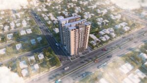 Aerial view of Da Manara residential tower surrounded by houses, streets, and greenery under a sunny day with clouds.